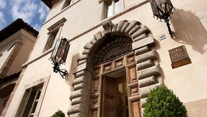 Un edificio con fachada de piedra, una puerta de madera y dos macetas.