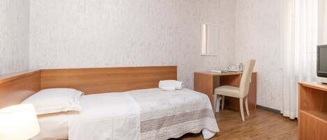 Una habitación de hotel con una cama de madera, un escritorio, una silla y un televisor.