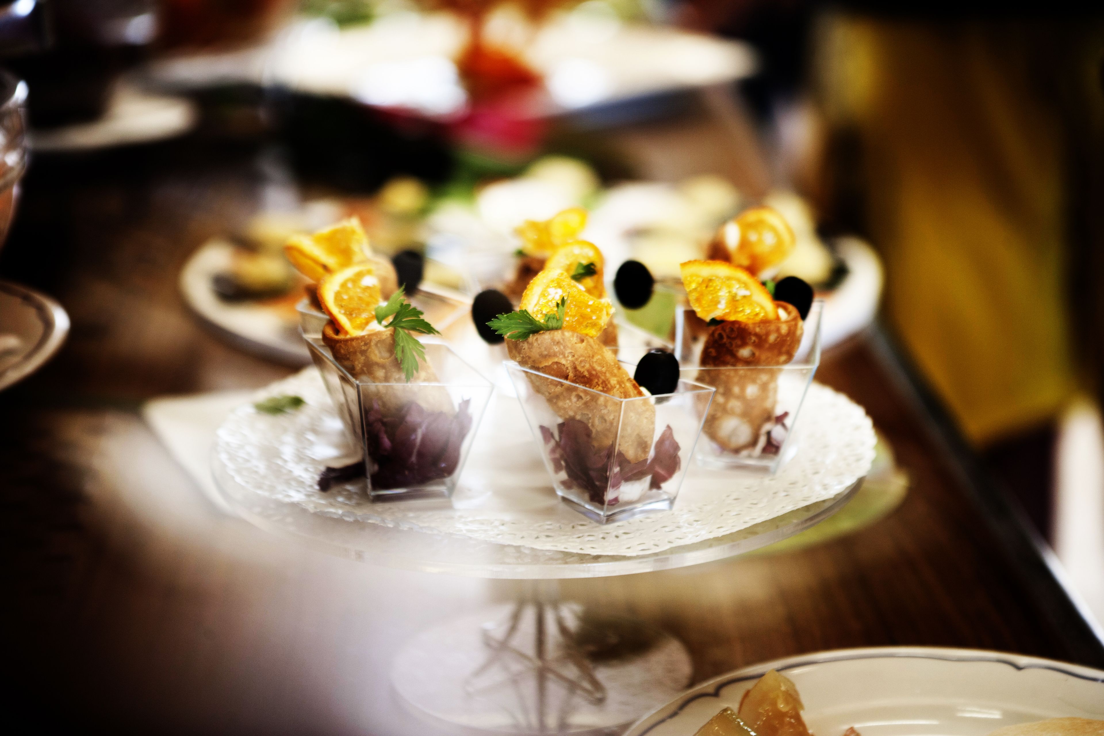 Ein Desserttisch mit verschiedenen kleinen Schalen, gefüllt mit Desserts, verziert mit Früchten und Kräutern.