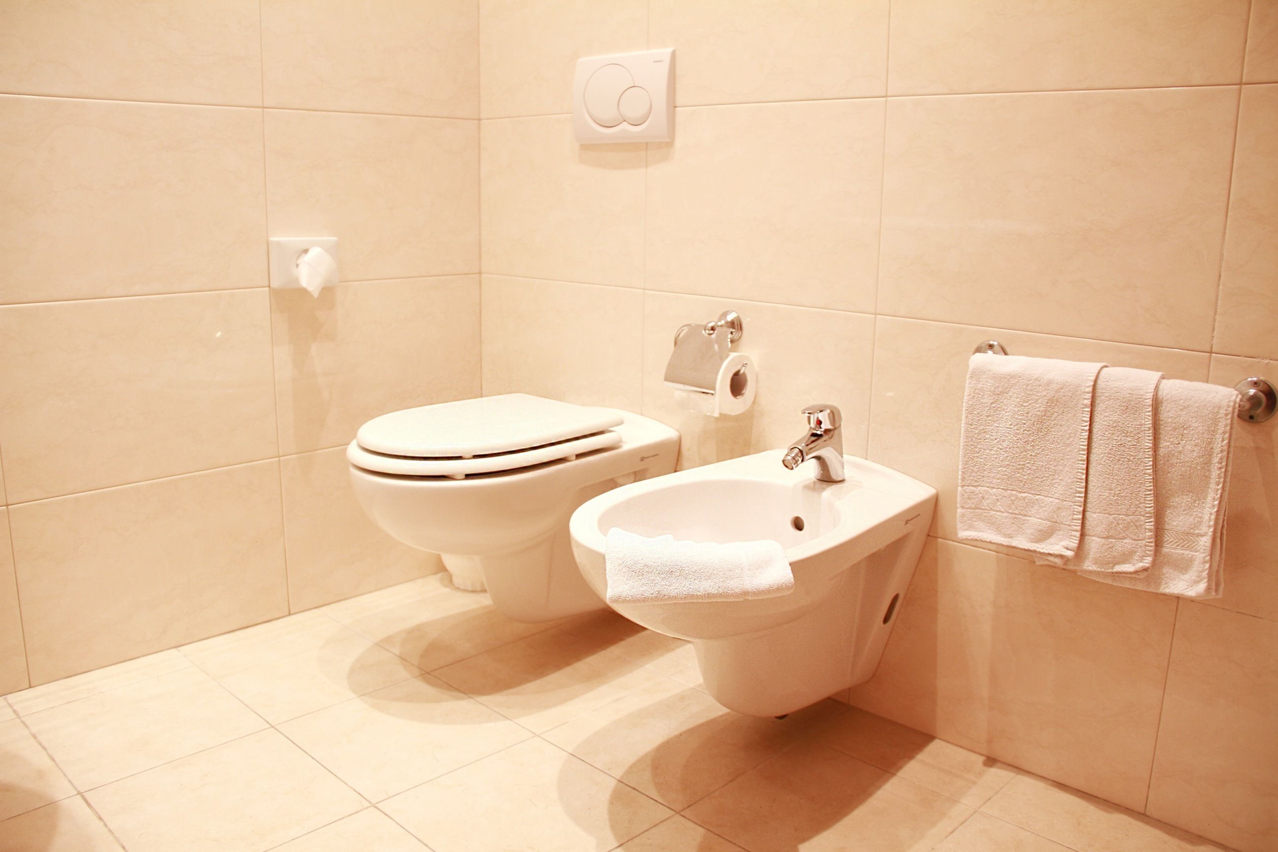 A bathroom with a toilet, bidet, and sink.