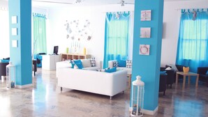 Een moderne woonkamer met een witte bank, blauwe accenten en een decoratieve lantaarn.