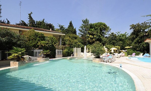 Alberca techada, alberca al aire libre y camastros