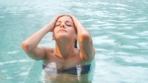 Une personne dans une piscine, avec une fontaine en arrière-plan.
