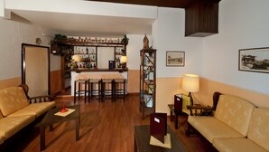 A cozy living room with a sofa, a coffee table, and a dining area with a bar in the background.