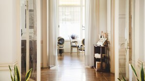 A hallway with a dining area, wooden flooring, and a view of the outdoors through a window. - Hotel Ghiffa (Ghiffa)