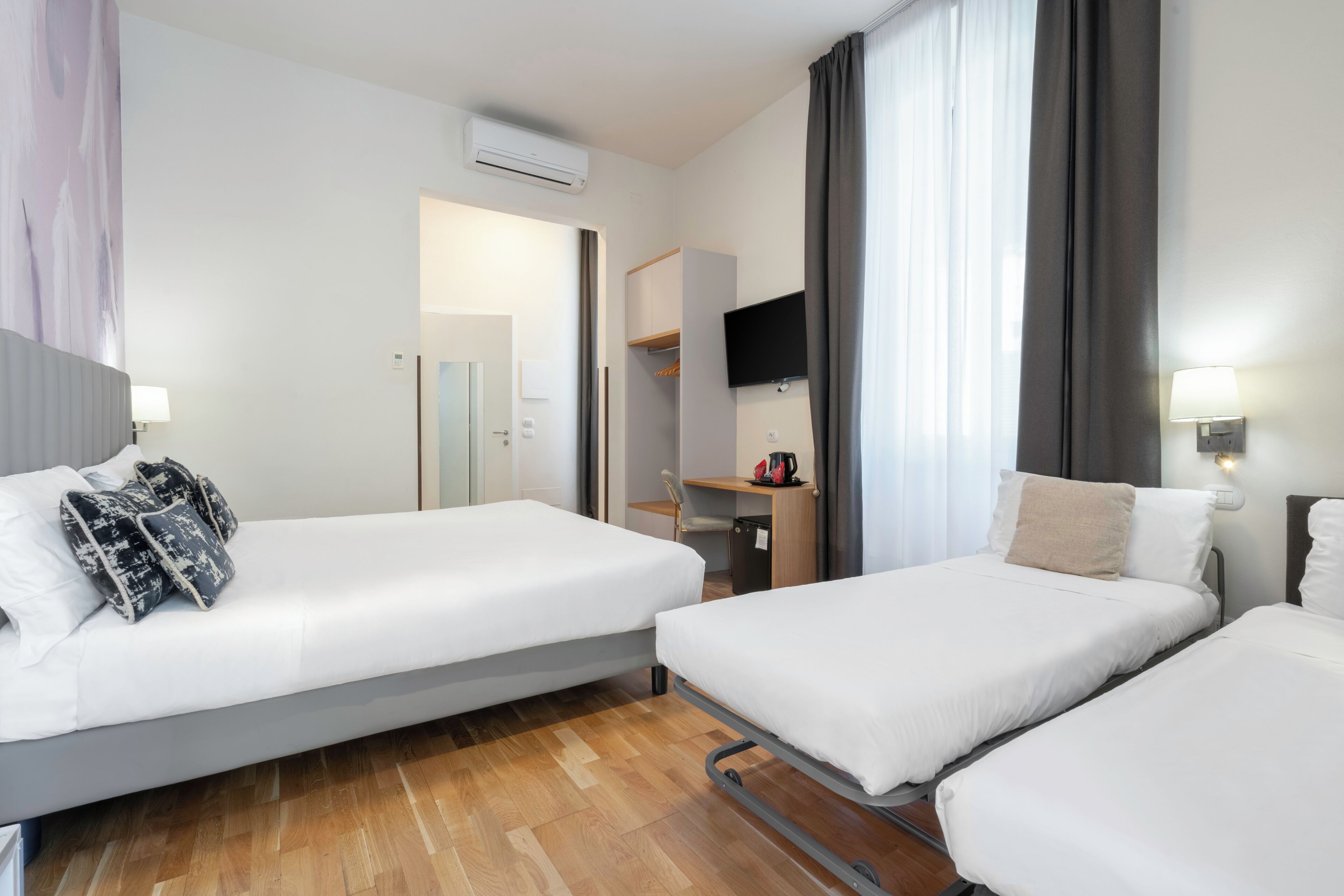 Habitación cuádruple clásica | Edredones de plumas, minibar, caja fuerte y escritorio