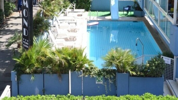 Un área de piscina con un cartel que dice "DIAMOND" y un edificio con balcones.