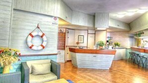 Un interior acogedor con suelo de madera, una encimera central tipo isla y una zona de estar con sofá y sillones.