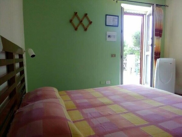 Ein Zimmer mit Bett, Fenster und Tür.