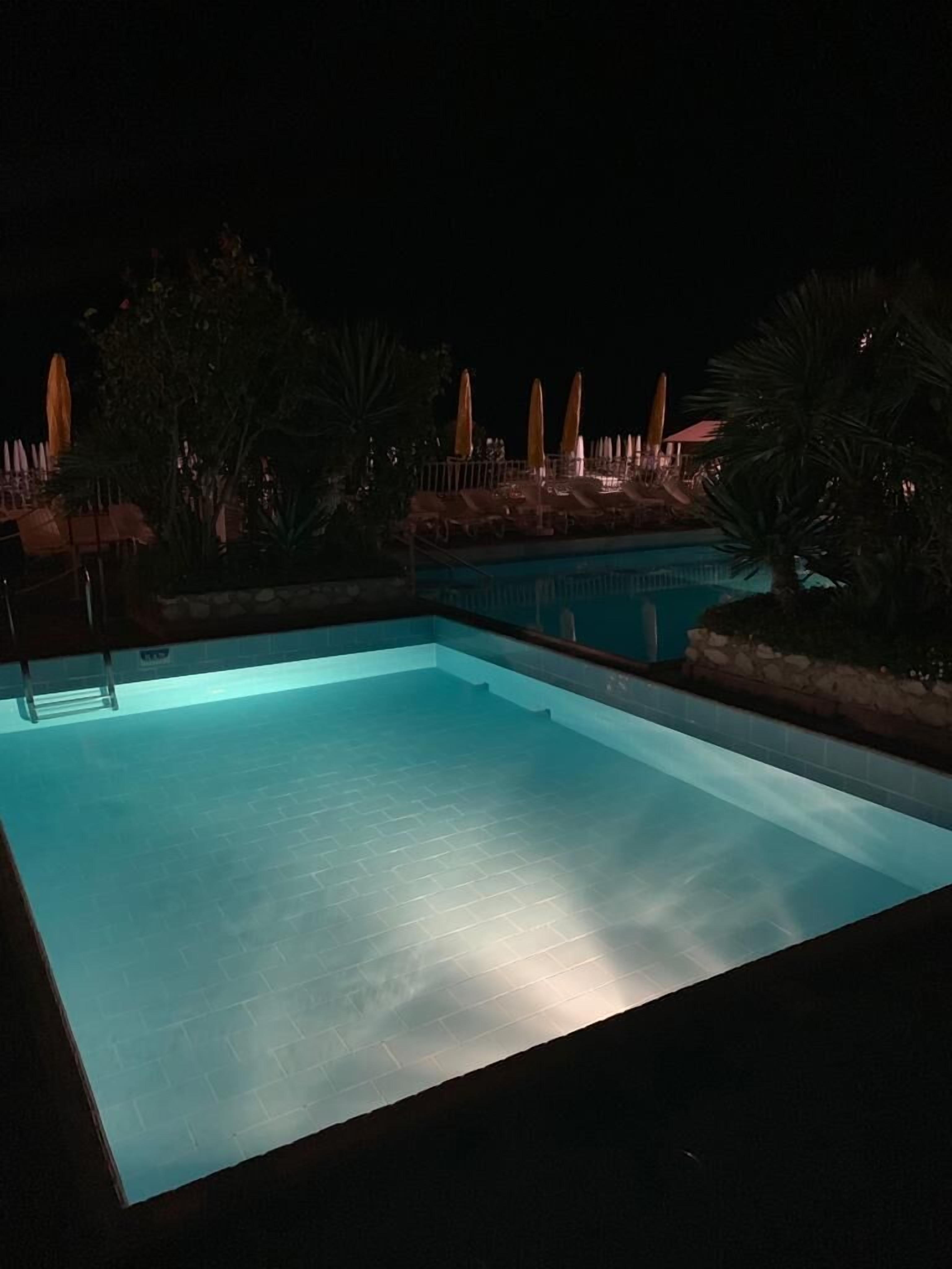Una piscina al aire libre, sillones reclinables de piscina