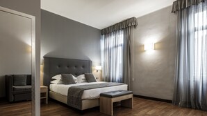 Un dormitorio moderno con una cama grande, una mesita de noche, un banco y un sofá.