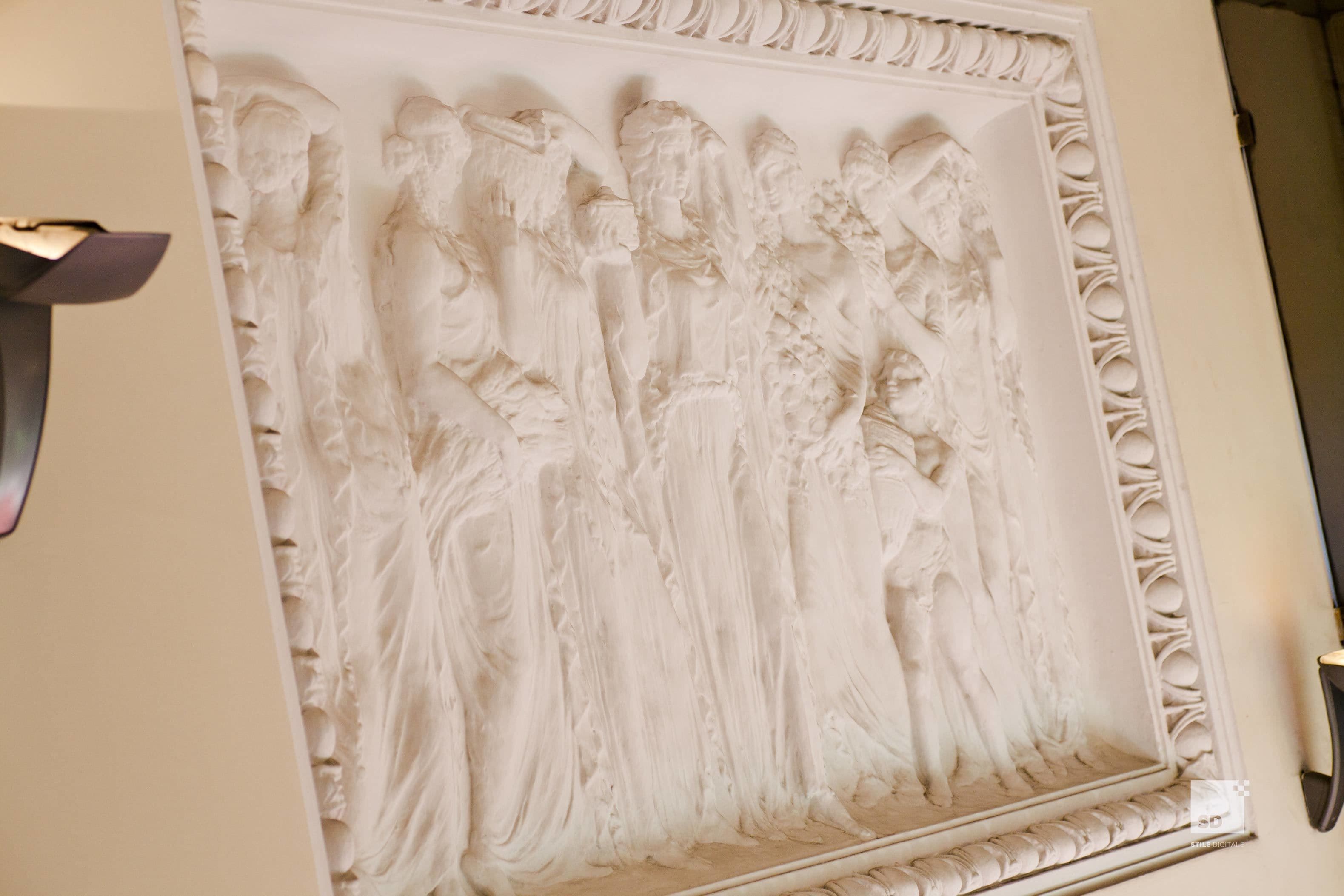 A detailed wall relief with a classical design, likely part of a hotel's interior decor.