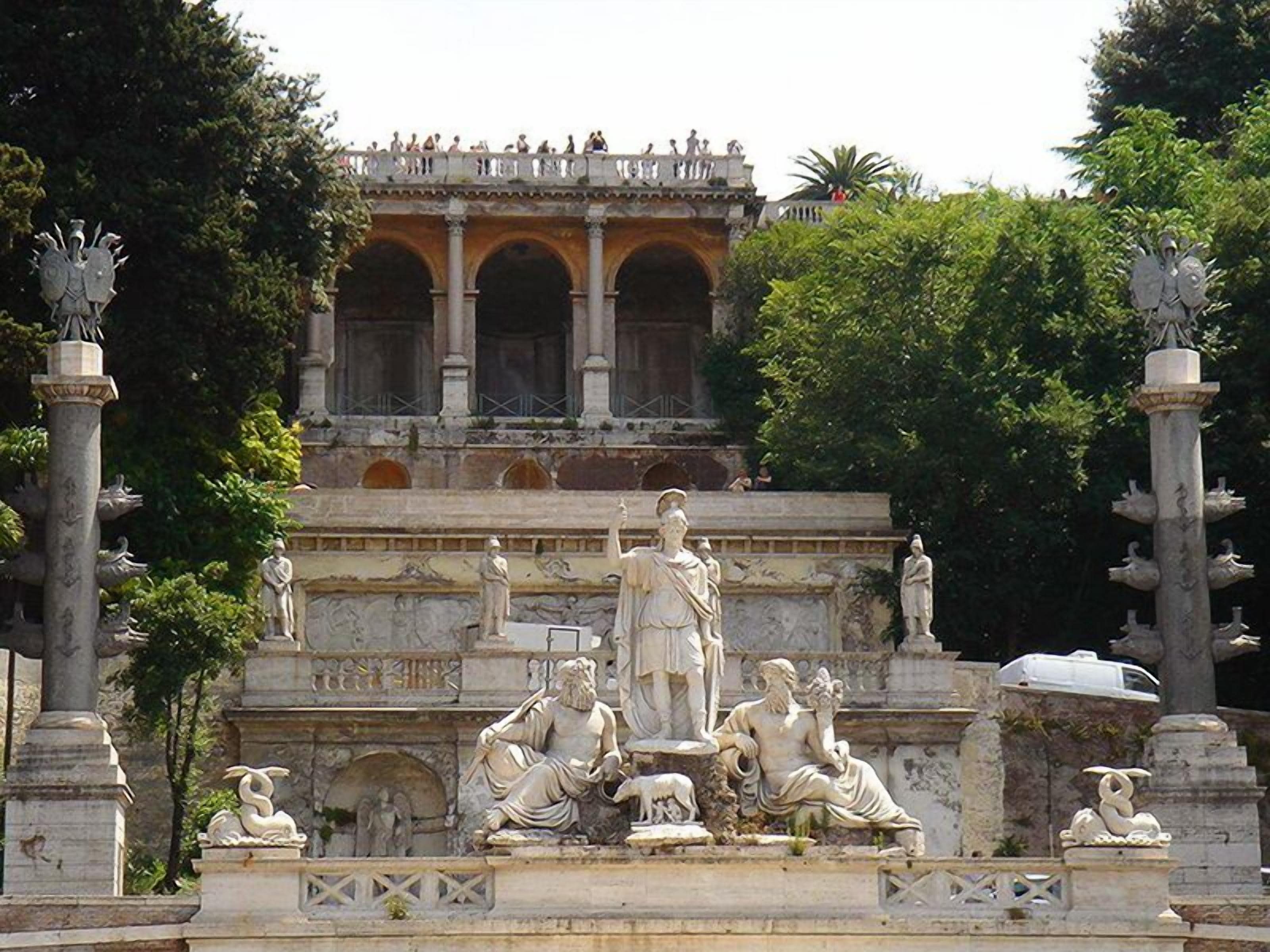 A classical garden with statues and a fountain.