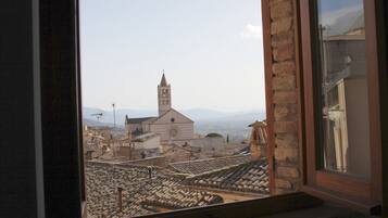 A view from a window overlooking a historic town with a prominent church and stone buildings.