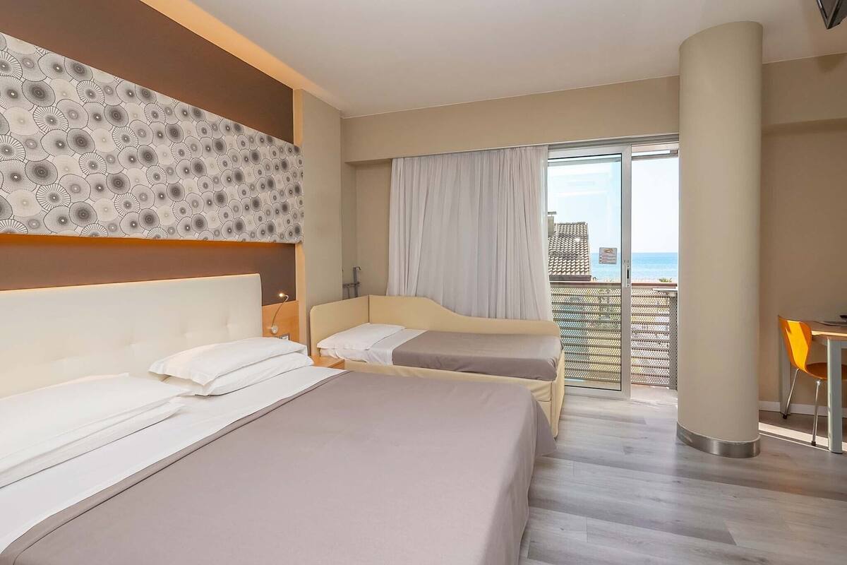 Driepersoonskamer, uitzicht op zee | Een kluis op de kamer, een bureau, verduisterende gordijnen, gratis wifi