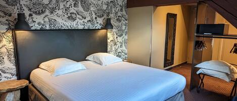 Une chambre moderne avec un grand lit, un mur décoratif, une petite table et un miroir.