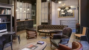 Un área de descanso moderna con un sofá, sillones, una mesa de centro y una estantería.