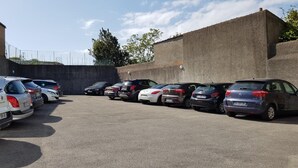 A parking lot with several cars parked in rows. - Brit Hotel Les Alizés (Pornic)