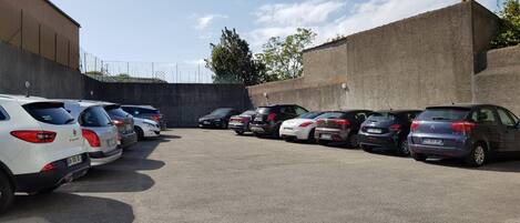 Un estacionamiento con varios coches aparcados en filas.