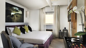 A hotel room with a bed, a chair, a table with a cup, and a painting on the wall. - Mario de Fiori 37 (Rome)
