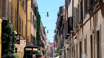 Un carrer empedrat flanquejat per edificis històrics, alguns amb persianes i balcons.