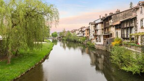 Un río con edificios a un lado y árboles al otro.