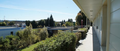 A covered walkway with a view of a bridge and a body of water.