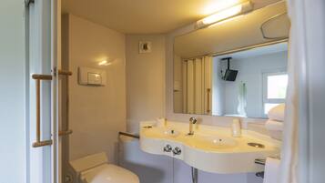 A compact bathroom with a white toilet, a sink with a mirror above it, and a towel rack.