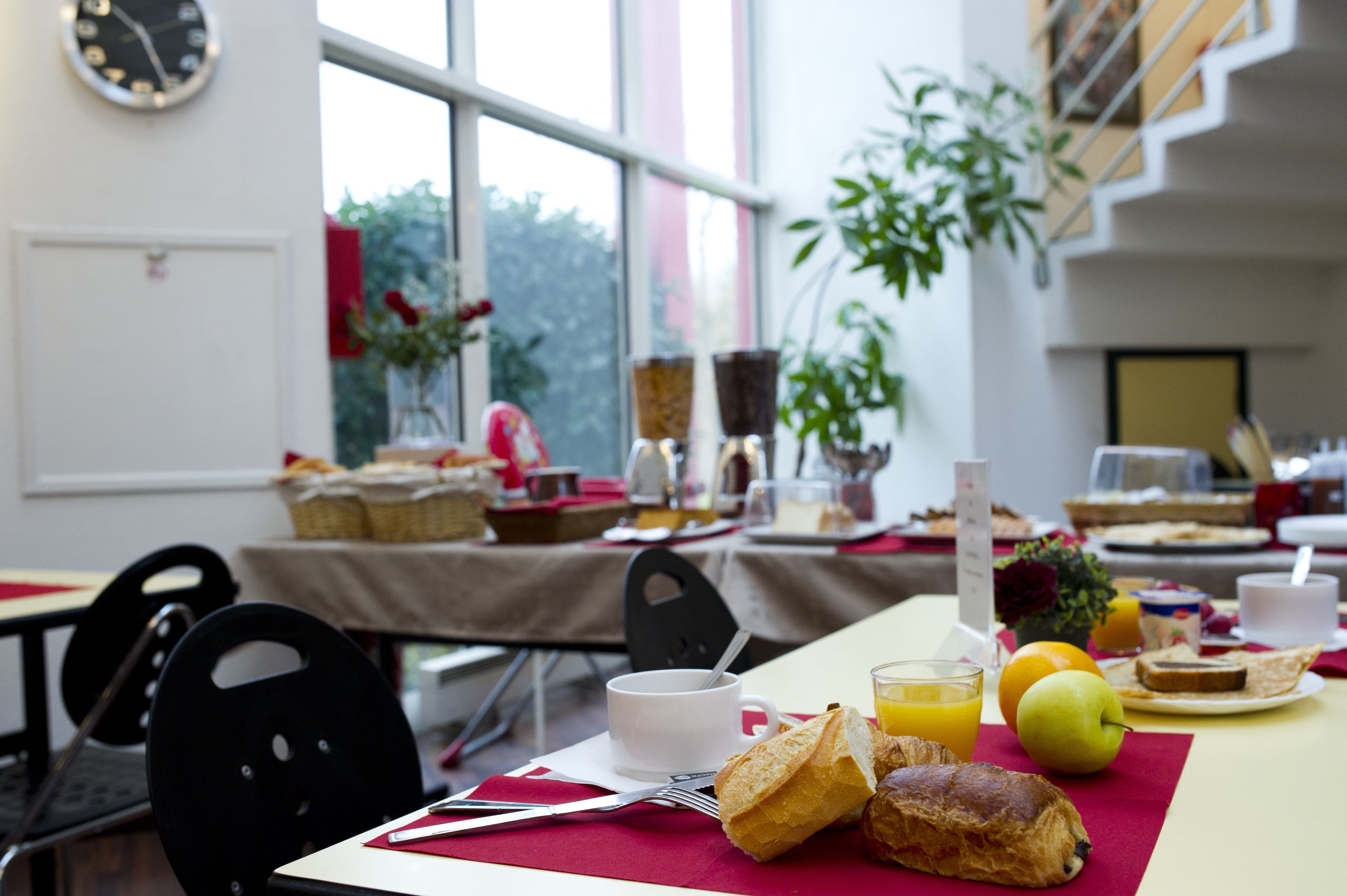 Une table de petit-déjeuner avec des croissants, des fruits et du jus.