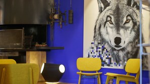 Un interior moderno con una gran impresión digital de un lobo, sillas amarillas y una lámpara negra.