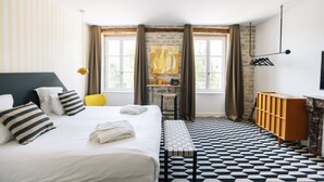 Una habitación de hotel con una cama grande, un escritorio, una silla y un armario.