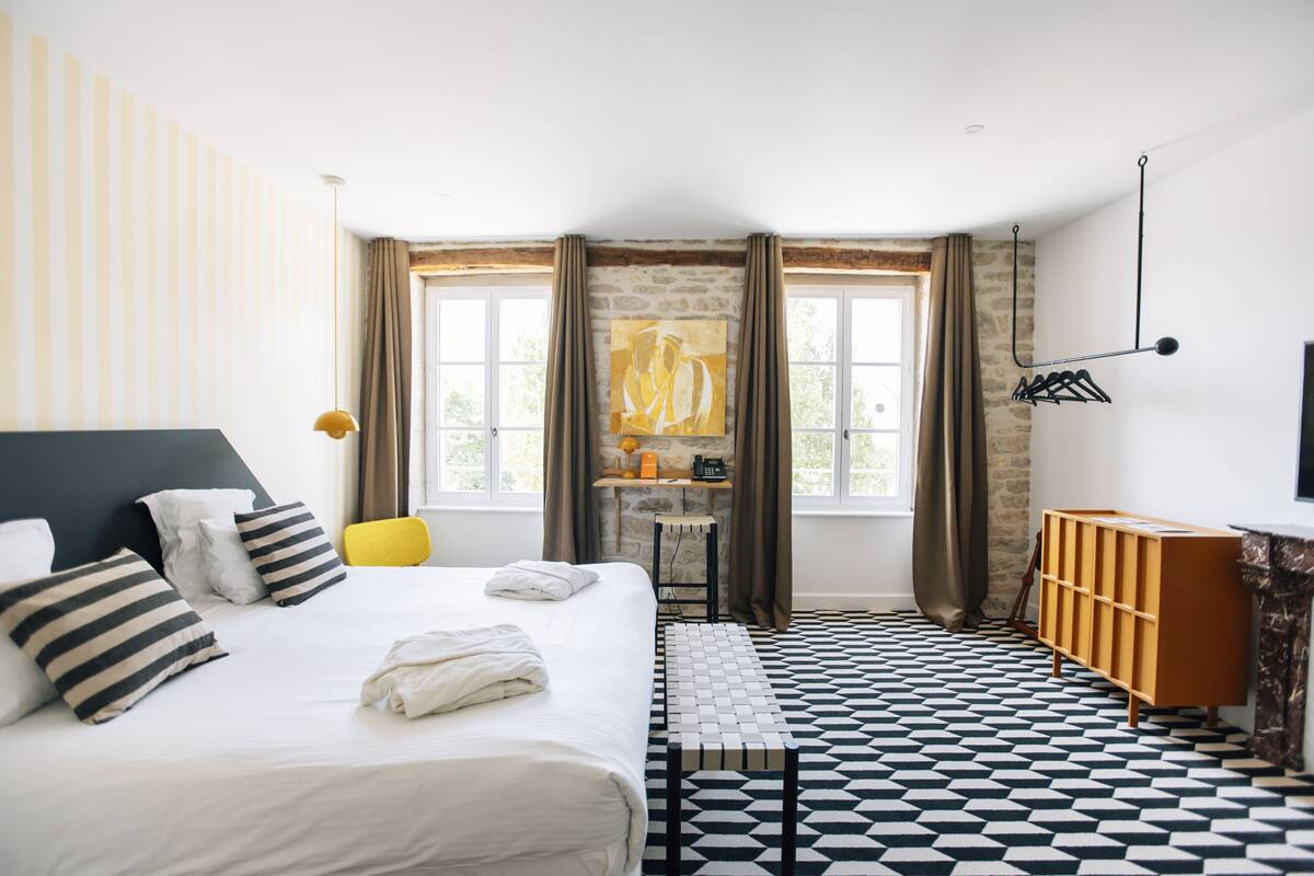 Hotellihuone, jossa on suuri sänky, työpöytä, tuoli ja vaatekaappi.