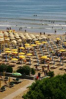 Una playa cerca, sillas reclinables de playa, sombrillas