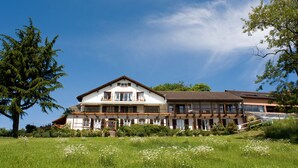 A two-story building with a balcony and a garden in front. - Le Clos Saint Vincent (Ribeauvillé)
