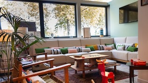 Una sala acogedora con un sofá, sillones, una mesa de centro y una estantería.