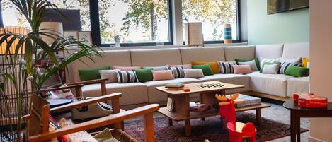 Un salon confortable avec un canapé, des fauteuils, une table basse et une bibliothèque.