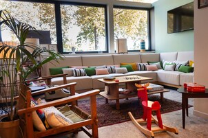 Una sala acogedora con un sofá, sillones, una mesa de centro y una estantería.