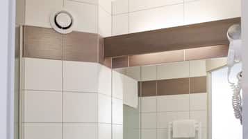 Un baño moderno con inodoro, lavamanos y espejo.