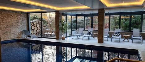 Een binnenzwembad en ligstoelen