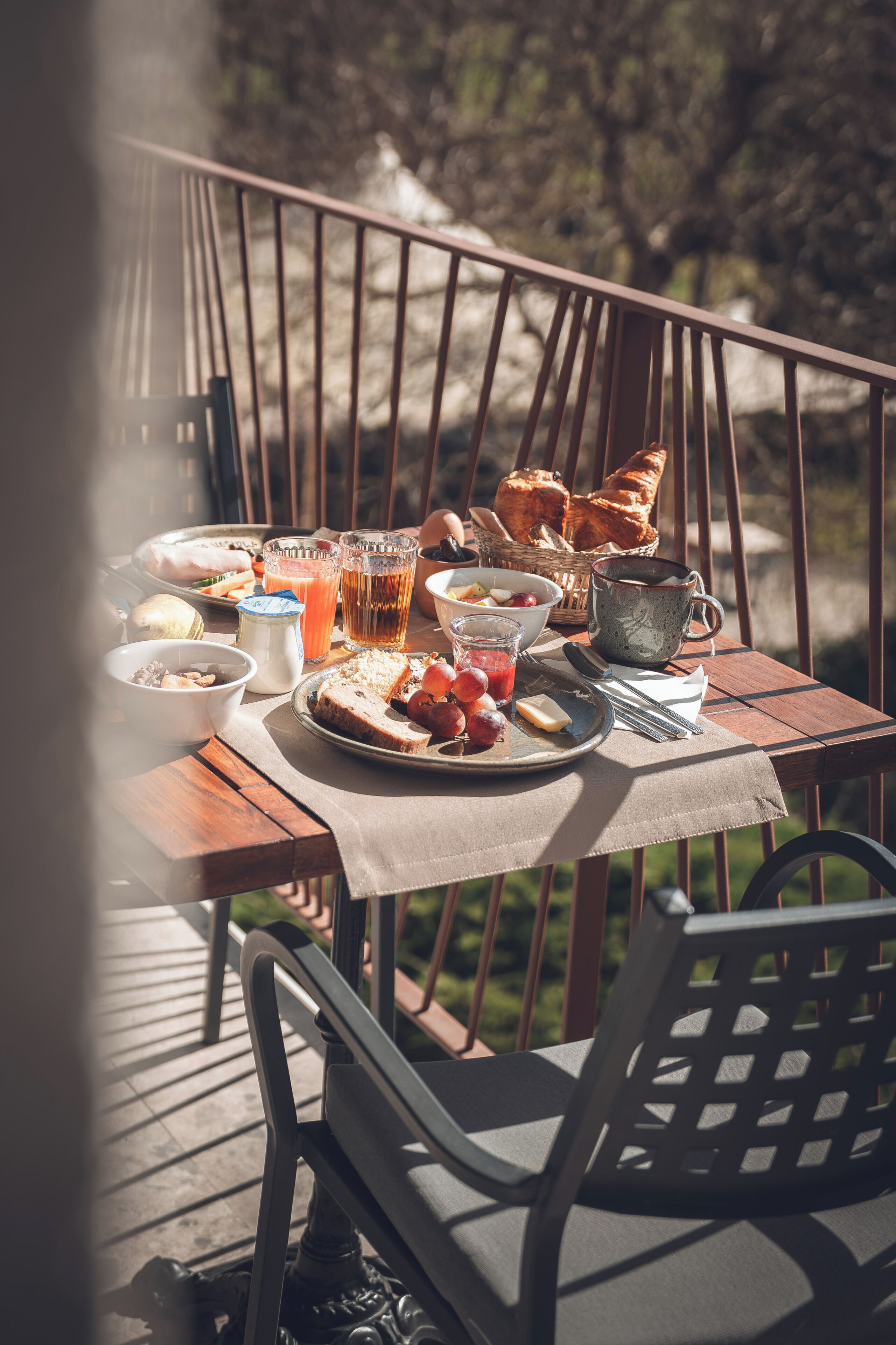 Ein Frühstückstisch im Freien mit verschiedenen Speisen und Getränken.