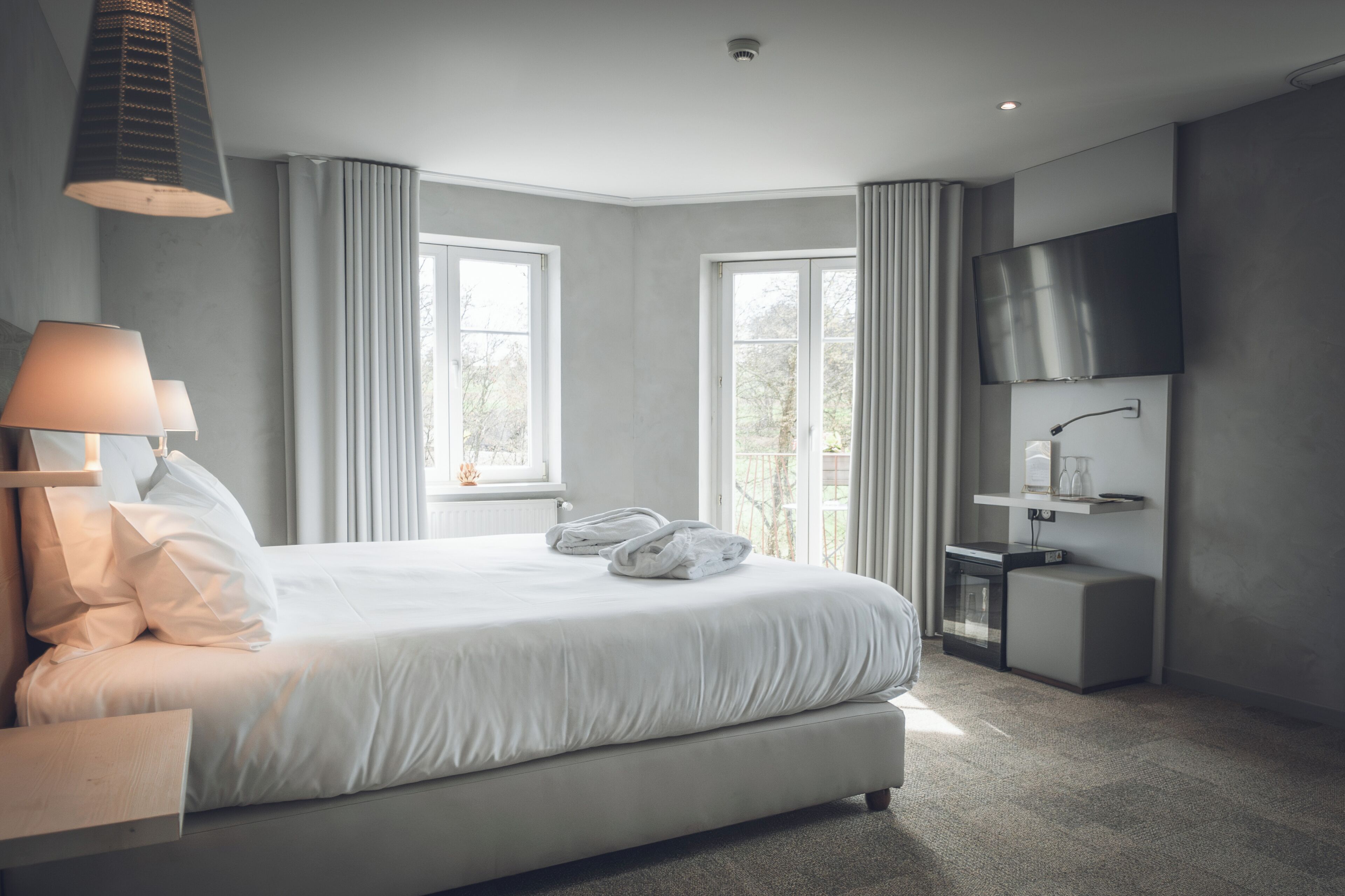 Een moderne hotelkamer met een groot bed, een flatscreen televisie en een klein nachtkastje.