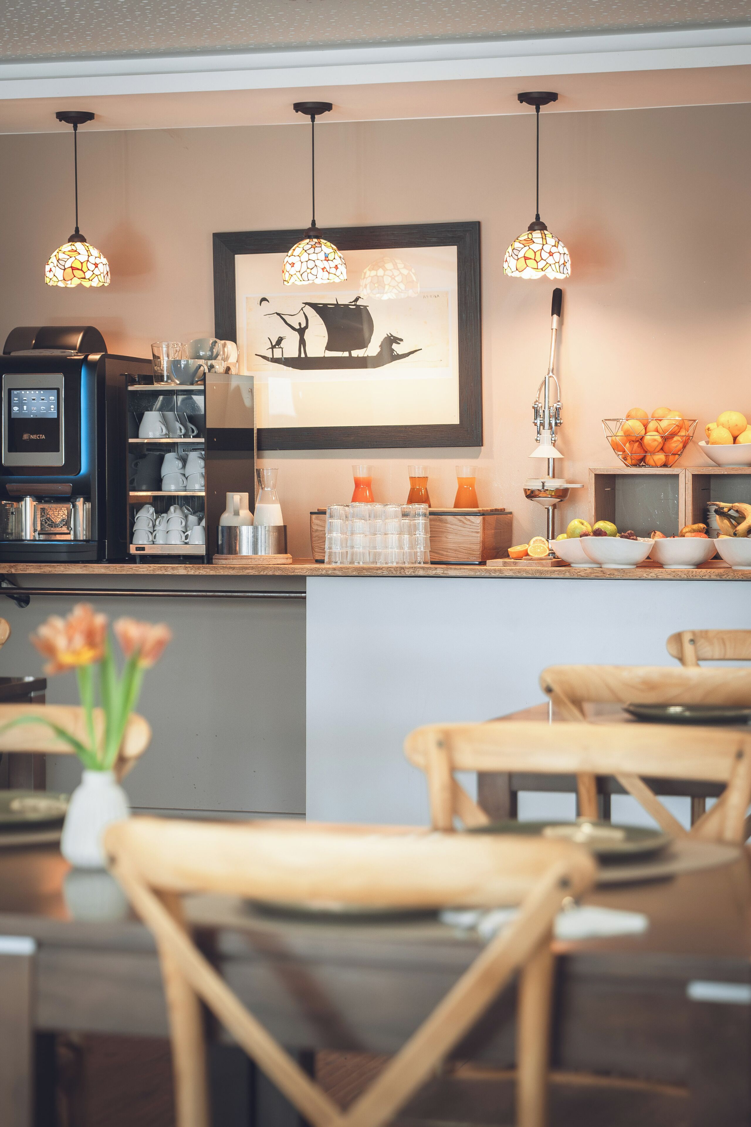 A cafe interior with a coffee machine, seating area, and decorative elements.