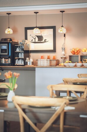 A cafe interior with a coffee machine, seating area, and decorative elements. - Hôtel Jenny (Hagenthal-le-Bas)