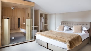 A modern bedroom with a large bed, a glass-enclosed walk-in closet, and built-in shelving. - La Terrasse (Douai)