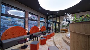 A modern lounge area with seating, tables, and potted plants. - La Terrasse (Douai)