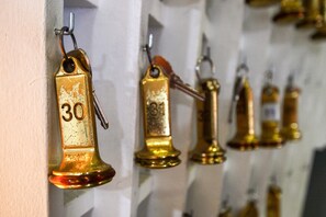 A row of golden bells with numbers 30, 31, and 32, hanging on a wall.