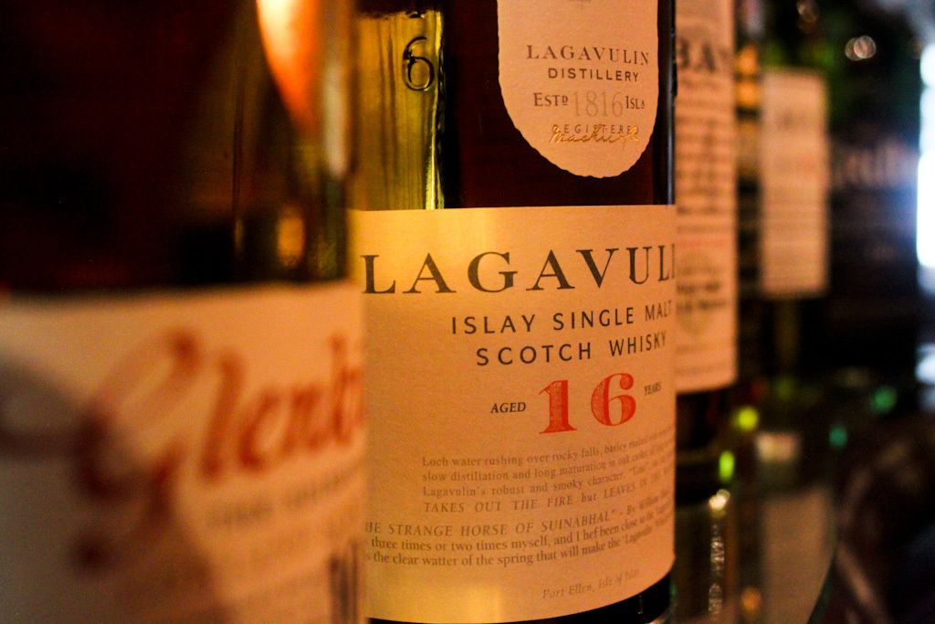 A close-up of a Lagavulin Islay Single Malt Scotch Whisky bottle with a label indicating it is aged 16 years.