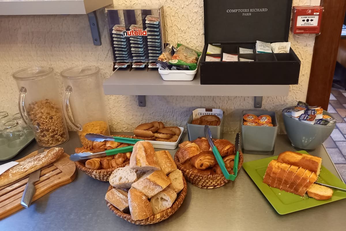 Een ontbijtbuffet met diverse broden, gebak en toevoegingen.
