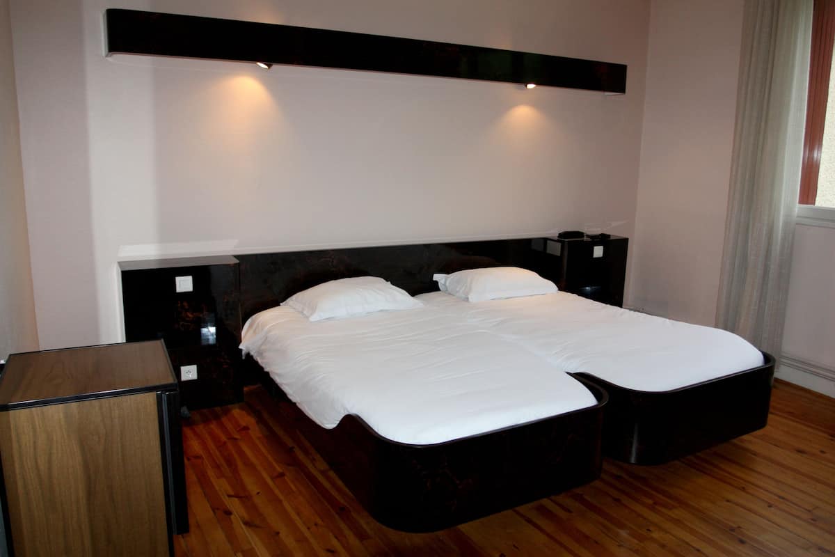Een keurig opgemaakte slaapkamer met een groot bed, nachtkastjes en een hoofdbord.