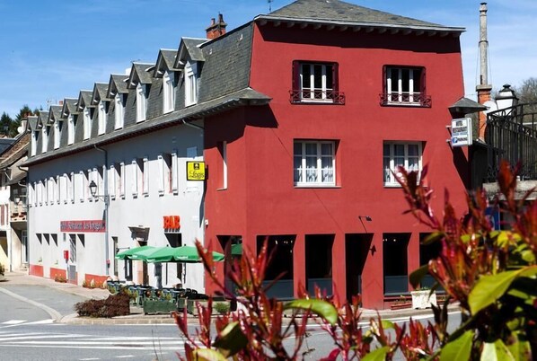 Un edificio rojo con un letrero de hotel y restaurante.